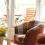 Modern und gemütlich eingerichteter Wohnbereich mit Terrassenzugang und Blick auf die See.